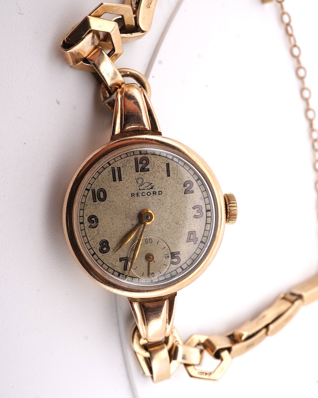 A lady's 9ct gold Record manual wind wrist watch, with Arabic dial and subsidiary seconds, on a 9ct gold bracelet, gross weight 16 grams. Condition - fair